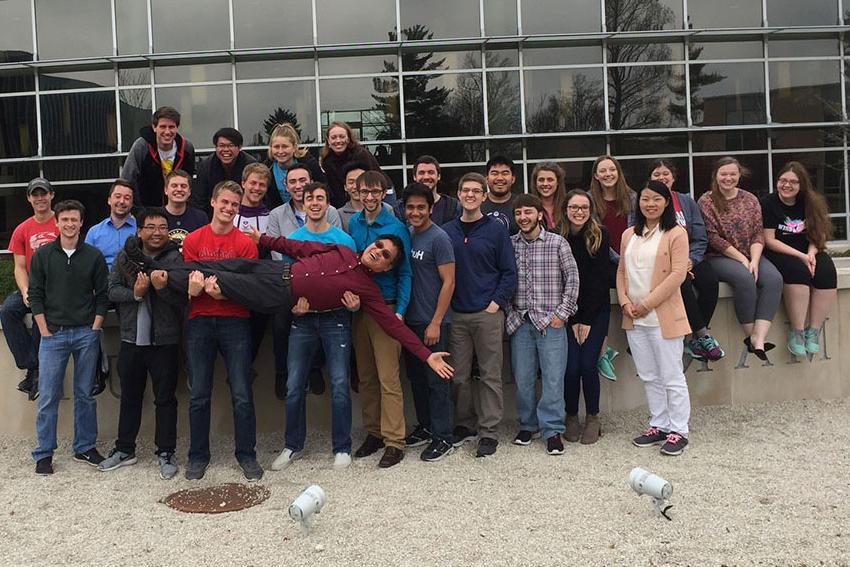 Data Science program director Guangwei Fan with students in front of Gander Hall